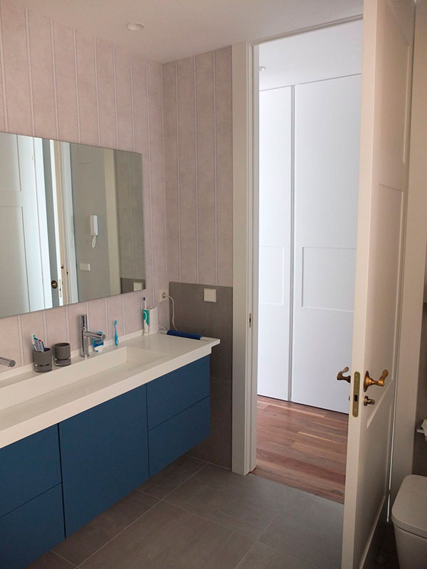 baño con mueble azul y espejo