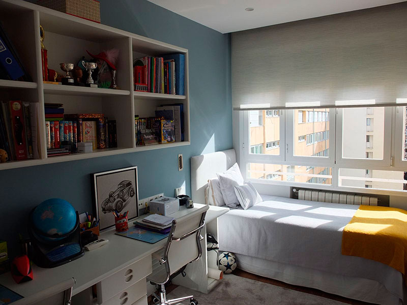 Dormitorio con una cama, escritorio y estanterías